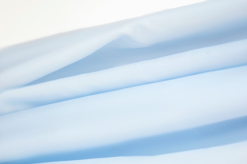 Close-up of soft blue fabric showing smooth texture and gentle folds.