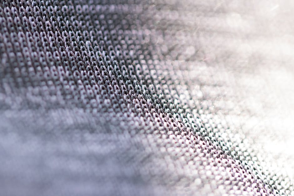 Macro shot of detailed knitted fabric texture with soft focus and light gradient effect.
