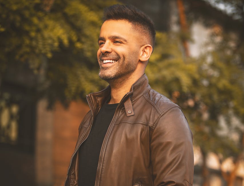 Portrait of a smiling man in a brown jacket outdoors in Tehran, Iran.