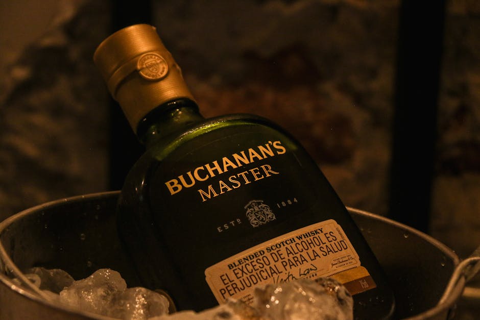 A bottle of Buchanan's Master Whiskey in an ice bucket with a warm ambiance.