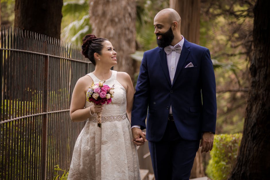A joyous bride and groom walking outdoors, exuding love and affection on their wedding day.