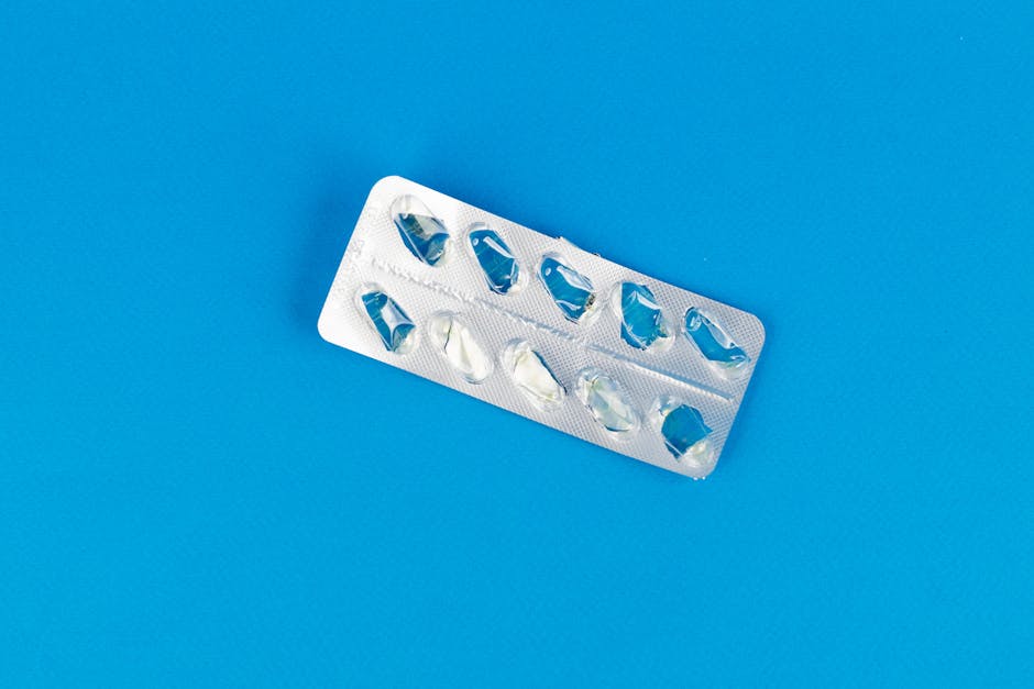 Top view of an empty blister pack on a bright blue background, highlighting medication and healthcare concept.